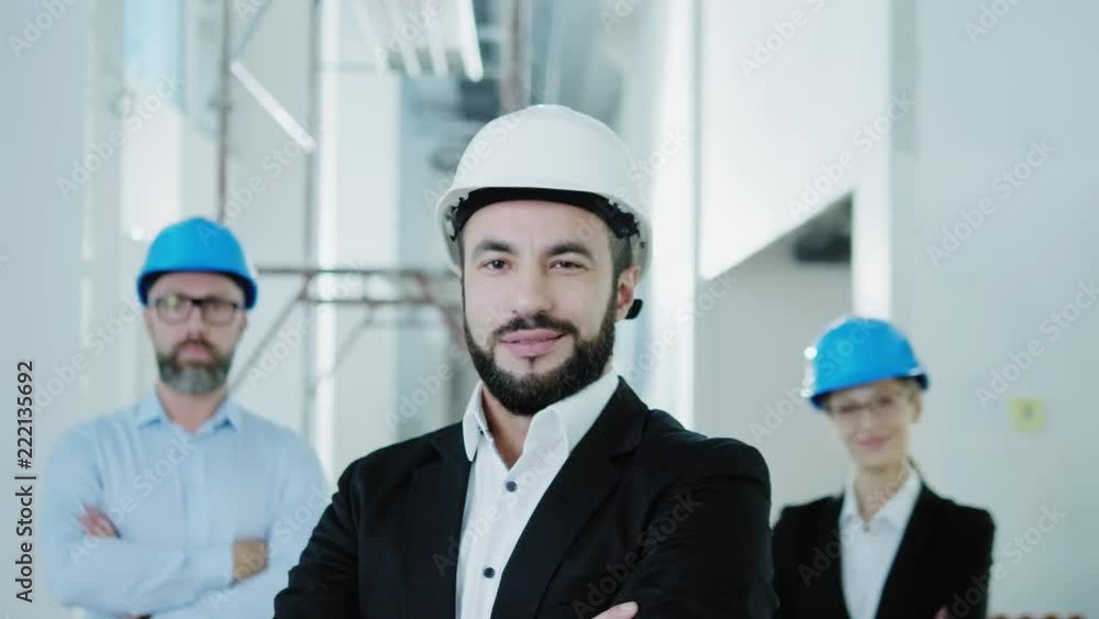 Engineers in hardhats have conversation in a factory Engineers in hardhats have conversation in a factory