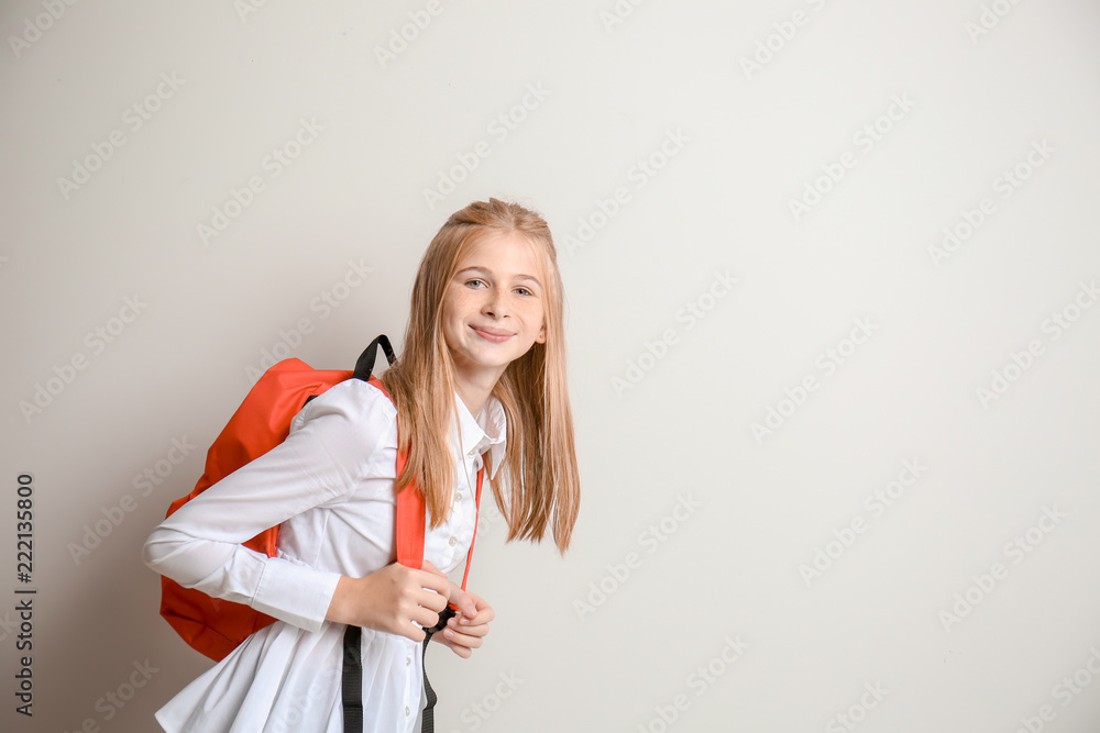 Cute schoolgirl with backpack on light background Cute schoolgirl with backpack on light background