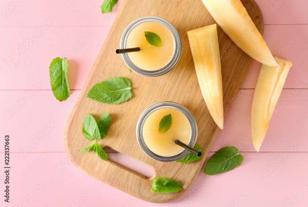 Glass jars with delicious melon smoothie on board Glass jars with delicious melon smoothie on board