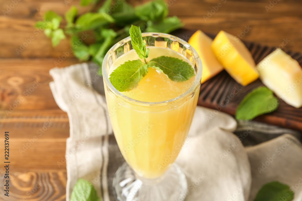 Glass with delicious melon smoothie on table, closeup Glass with delicious melon smoothie on table, closeup