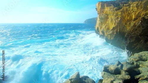 Watching the foaming waves of the storm from the rocky cliffs of San Lawrenz coast at former Azure Window site, Gozo Island, Malta. photo