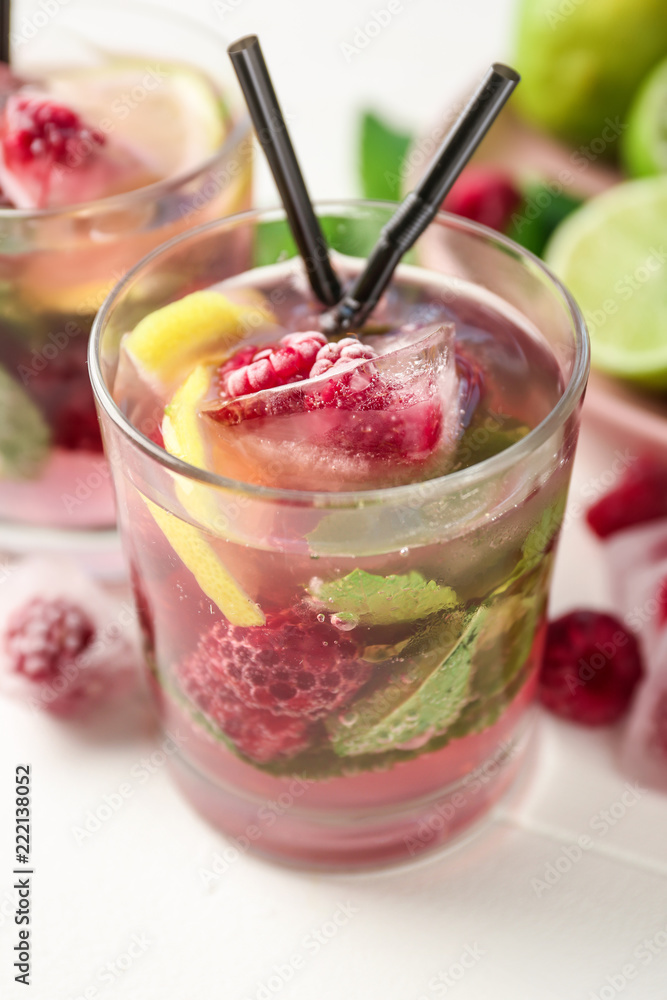 Glass of fresh raspberry mojito on light table Glass of fresh raspberry mojito on light table