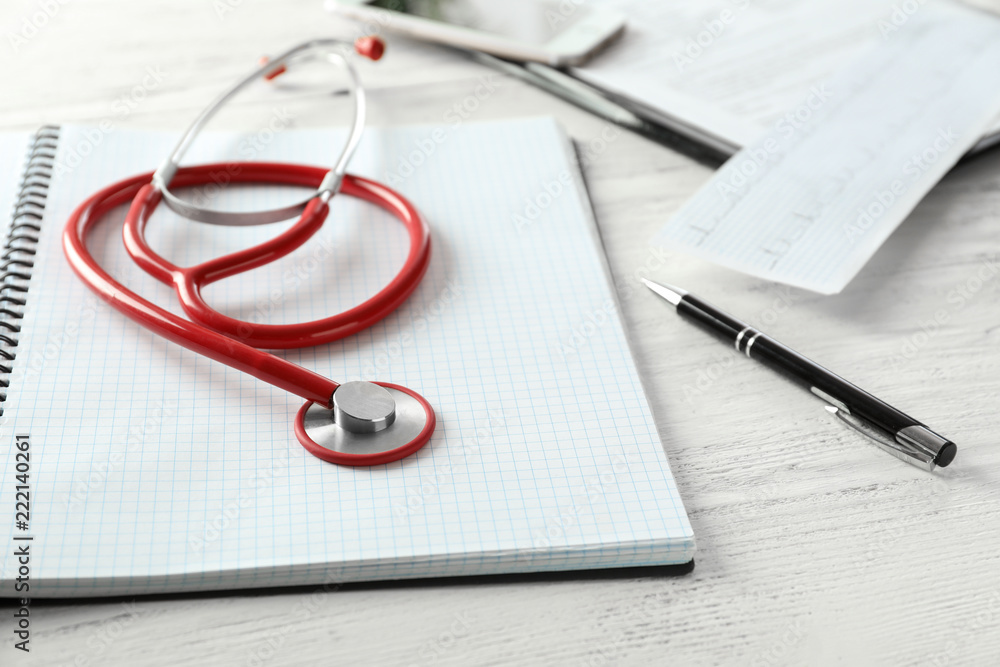 Medical stethoscope and notebook on white wooden background Medical stethoscope and notebook on white wooden background