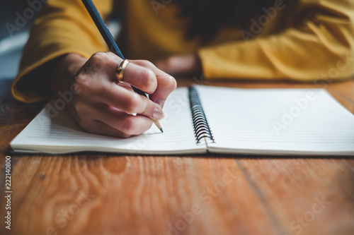 Close up woman hand writing on notebook photo
