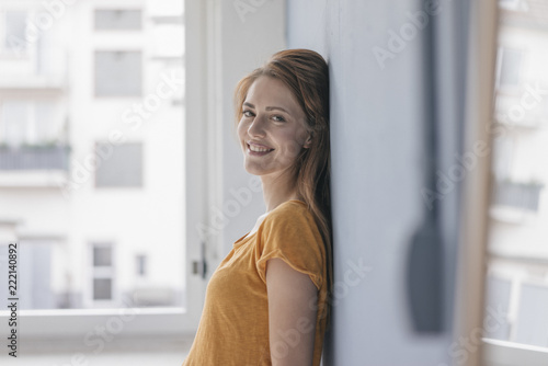 Happy woman leaning on wall