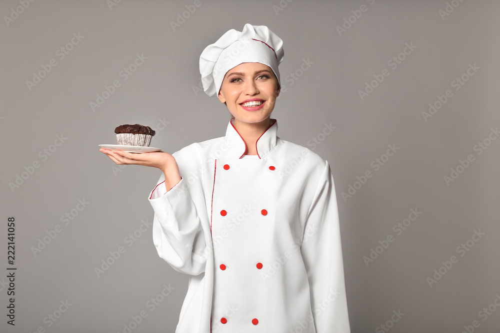 Young female chef on grey background Young female chef on grey background