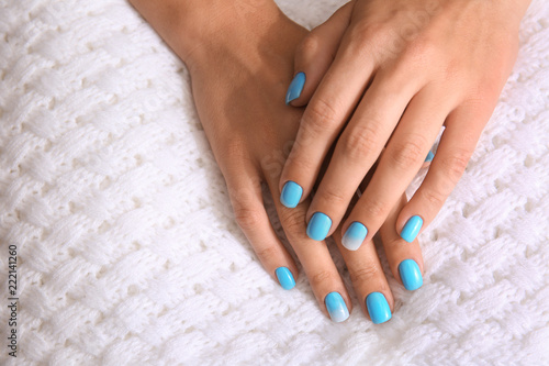 Hands of woman with professional manicure on fabric