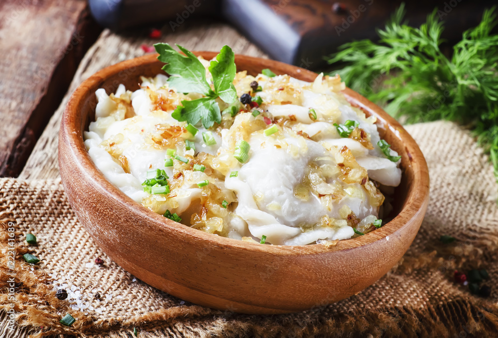 Traditional Russian vareniki with potatoes and fried onions in bowl on old wooden table, rustic style, selective focus Traditional Russian vareniki with potatoes and fried onions in bowl on old wooden table, rustic style, selective focus