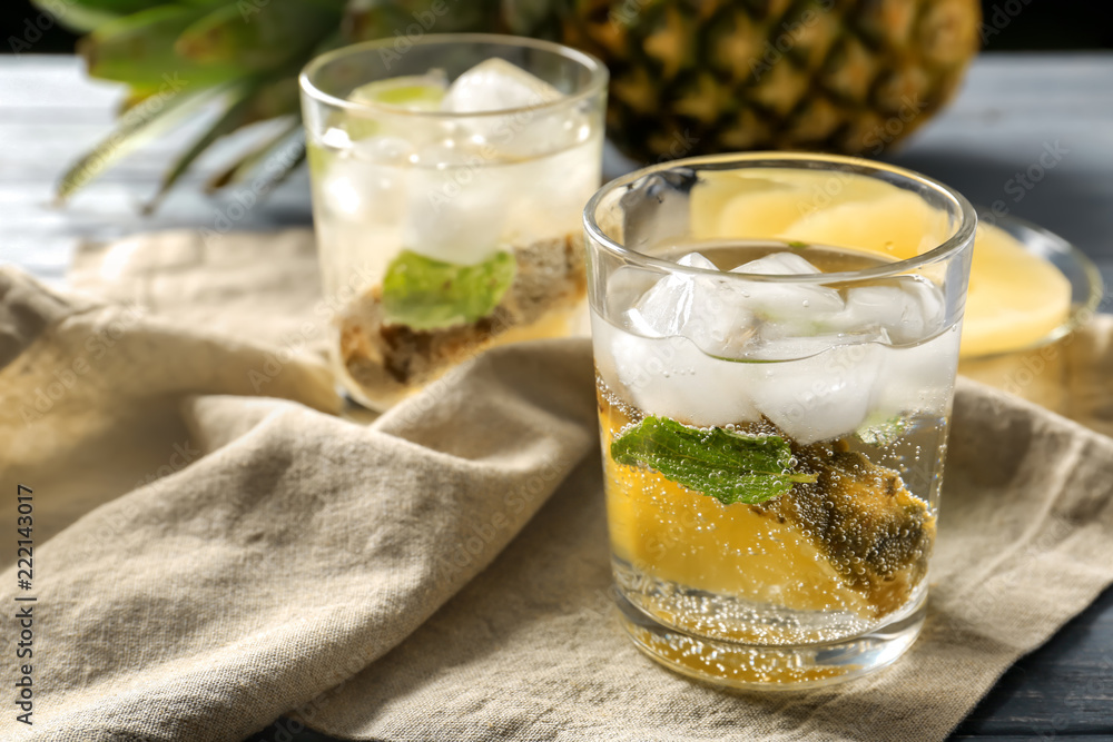 Tasty drink with ice and pineapple in glass on napkin Tasty drink with ice and pineapple in glass on napkin