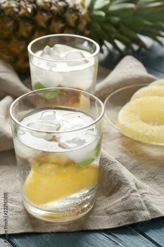 Tasty drink with ice and pineapple in glass on napkin
