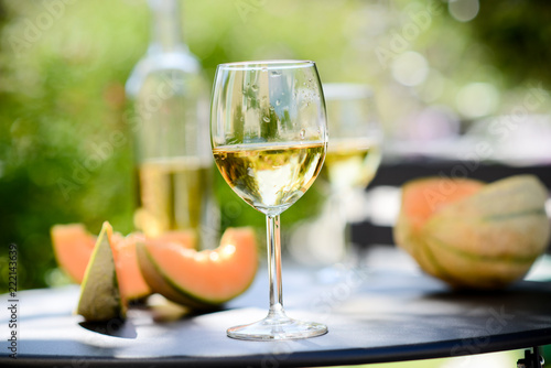 two glass of cool white wine with bottle outdoor in restaurant terrace during a sunny summer day