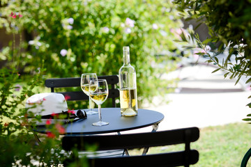 two glass of cool white wine with bottle outdoor in restaurant terrace during a sunny summer day