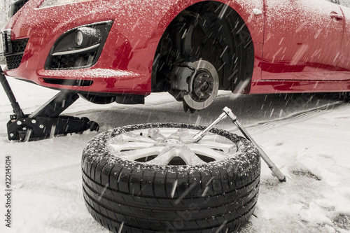 Winterreifenwechsel im Schnee während es schneit