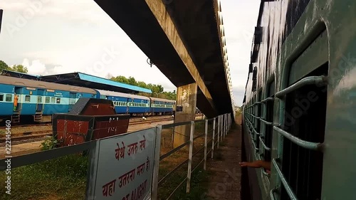 A real time clip shot from inside of a moving train capturing the green scenery including trees and grasslands photo