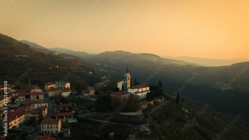 Aerial view of a typical small village in the Italian hills at sunset.