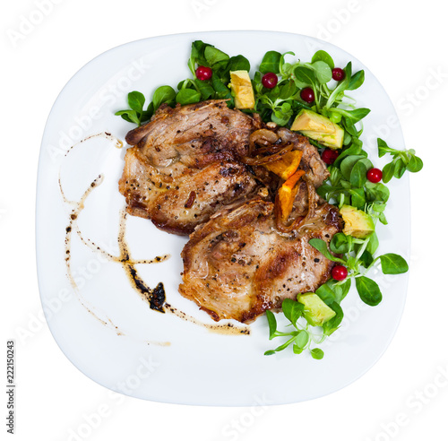 Cooked fried pork meat chops with with greens, avocado and berries