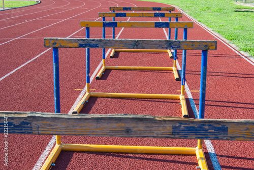 Five worn obstacles on athletics track in a row