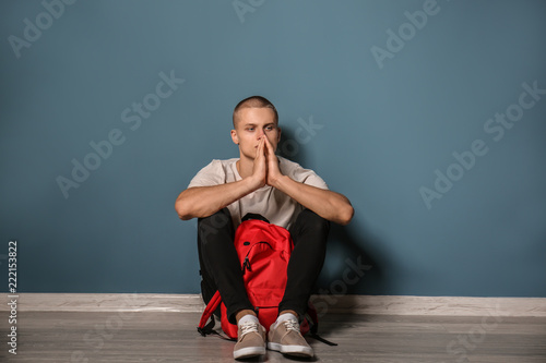 Sad teenage boy sitting nea...