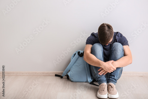 Sad teenage boy sitting on ...