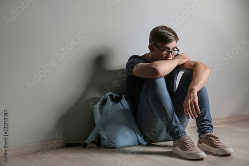Sad teenage boy sitting on ...