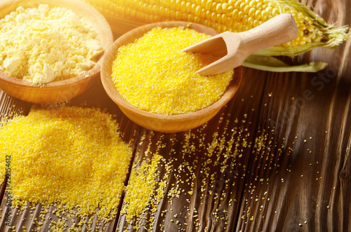 Photos Bowl of corn grits corncob and corn flour on kitchen table