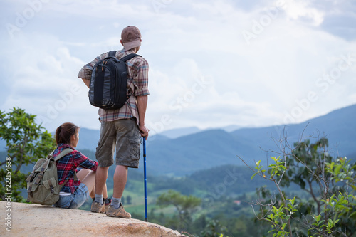 Hikers with backpacks relaxing on top of a hill. Traveling along mountains and coast, freedom and active lifestyle concept