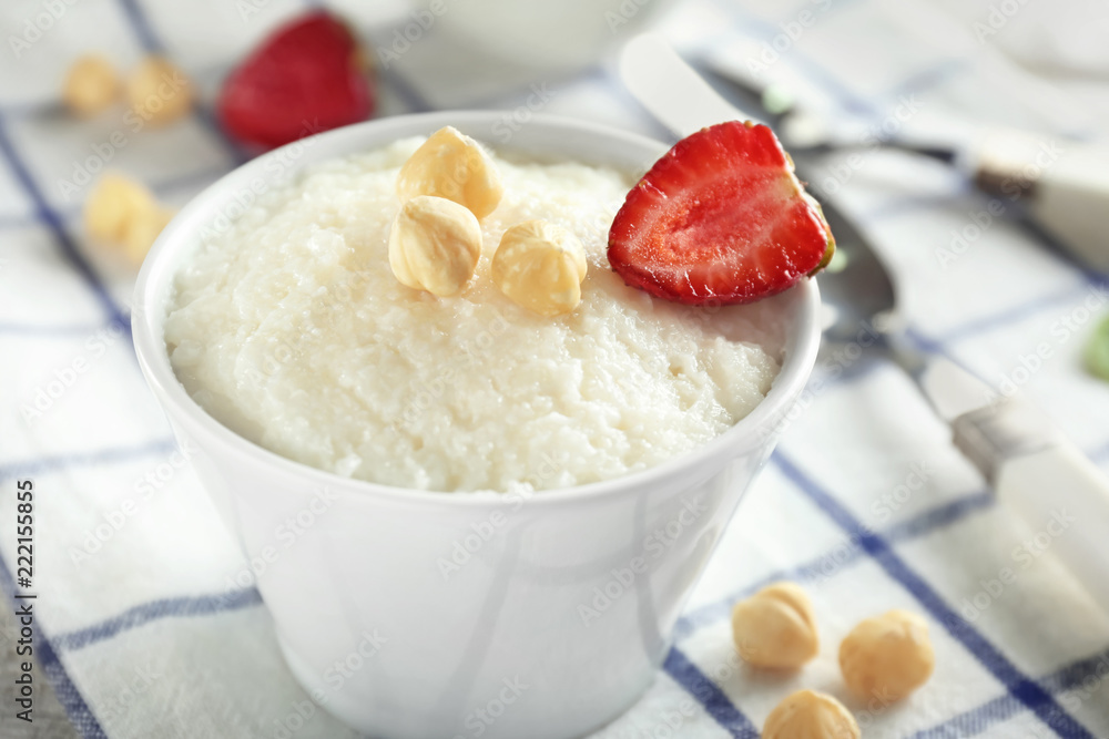 Delicious rice pudding with strawberry and hazelnuts in bowl on table Delicious rice pudding with strawberry and hazelnuts in bowl on table
