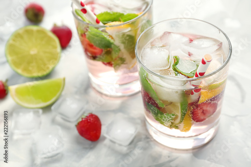Glasses of fresh strawberry lemonade on light table