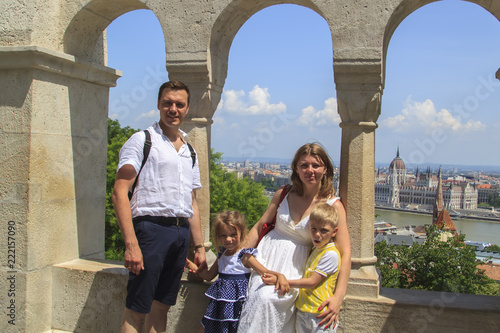 happy family traveling with two children smiling look at the camera on the streets of Budapest, Hungary