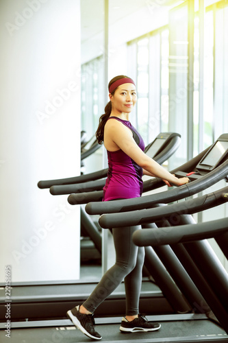 Asian female coach running on a treadmill