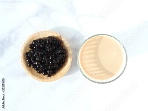 Top view of a glass cup of pearl milk tea (also called bubble tea) and a plate of tapioca ball. Pearl milk tea is the most representative drink in Taiwan. Taiwan food . With copy space.