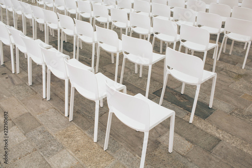 a lot of white empty chairs in a row  preparation for a concert  social event