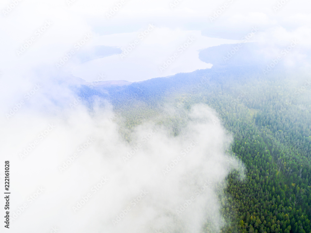 Aerial Drone view clouds over the green forest. Low lying cloud. Aerial view of over tropical rainforest. Above the clouds in the sky. Big clouds. Atmosphere and stratosphere. Top view from drone
