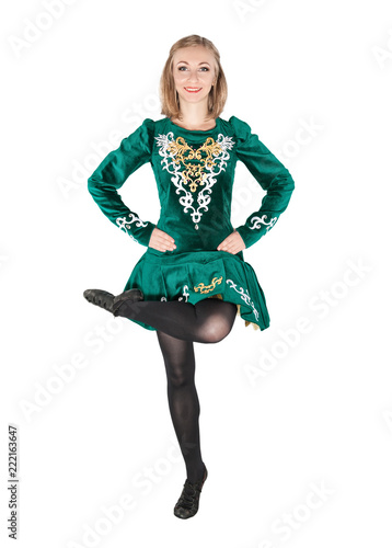 Beautiful young woman in Irish dance green dress jumping isolated