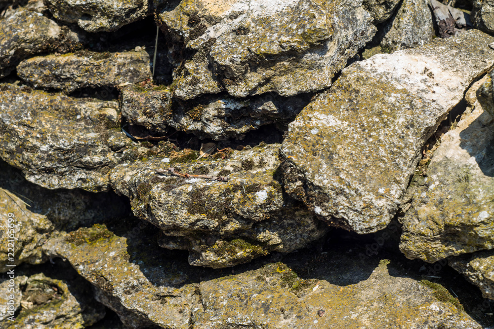 Stones background, gray large stones, boulders in the masonry, part of stone fence, close-up of stone border Stones background, gray large stones, boulders in the masonry, part of stone fence, close-up of stone border