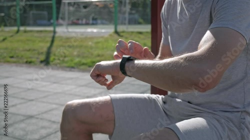 Athletic mans hands with smartwatch power on touching and scrolling. photo