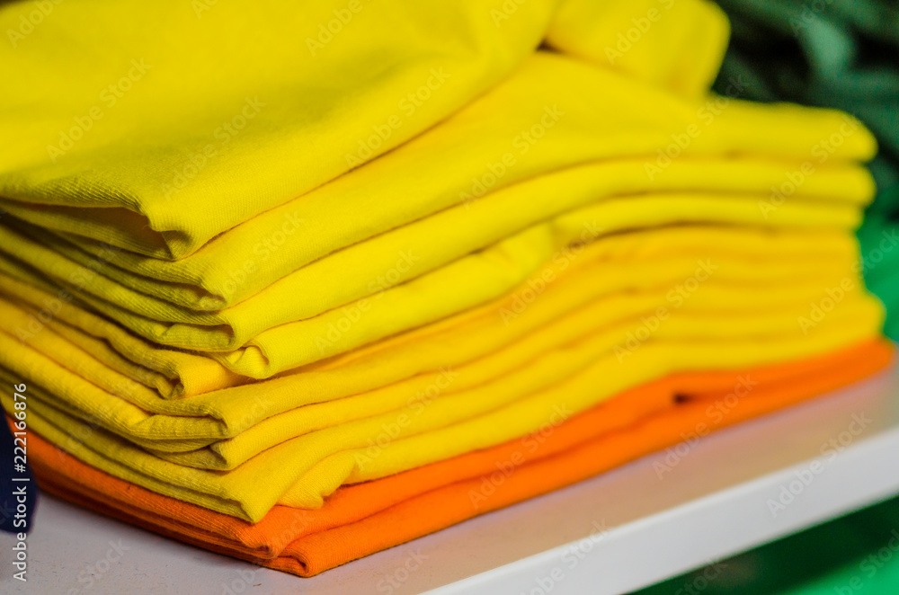 T-shirts made of multicolored fabric stacked in piles