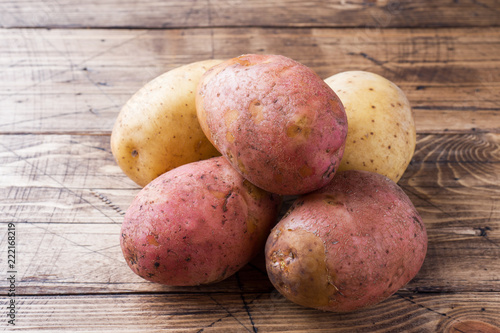 Raw potato red and yellow food. Fresh potatoes on wooden background.