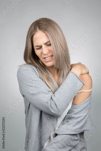young blond woman has a painful shoulder