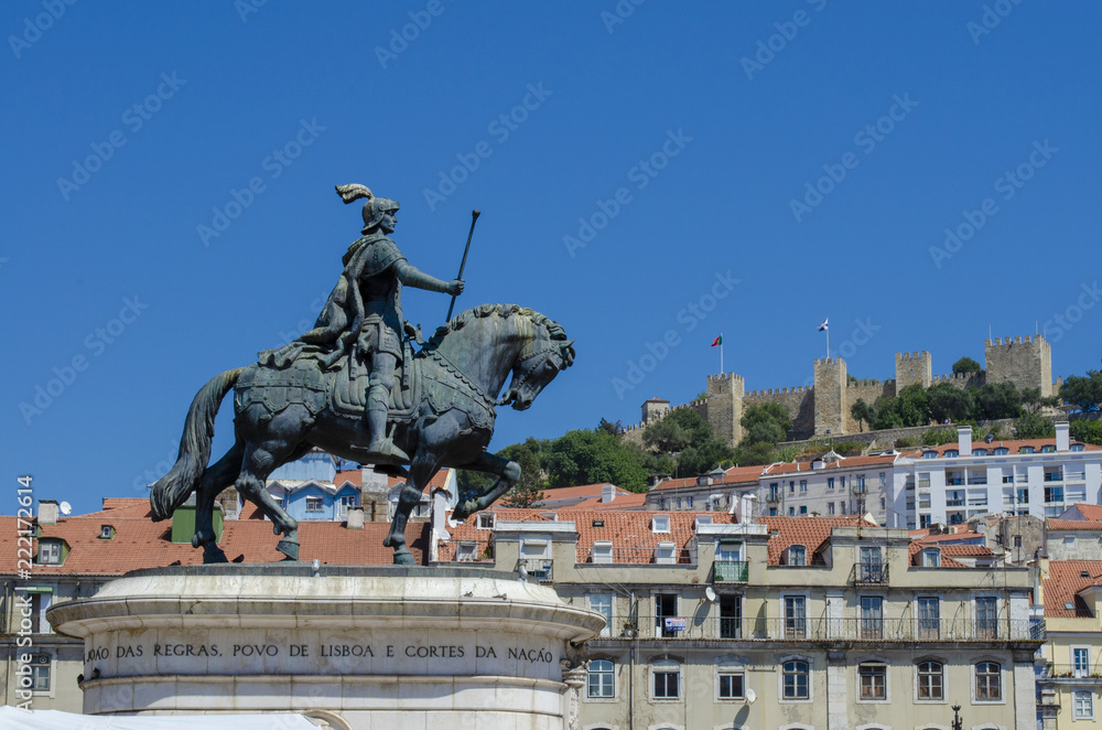 Obraz premium Estatua del rey Joao I en la Plaza Figueiroa y el Castillo San Jorge en Lisboa, Portugal