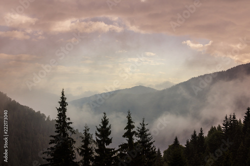 Summer mountain scenery with mist clouds  at sunset