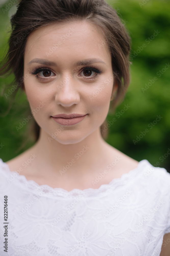 Close up portrait of young beautiful tender bride woman with nude make up in white wedding dress outdors in the park. Wedding concept Close up portrait of young beautiful tender bride woman with nude make up in white wedding dress outdors in the park. Wedding concept