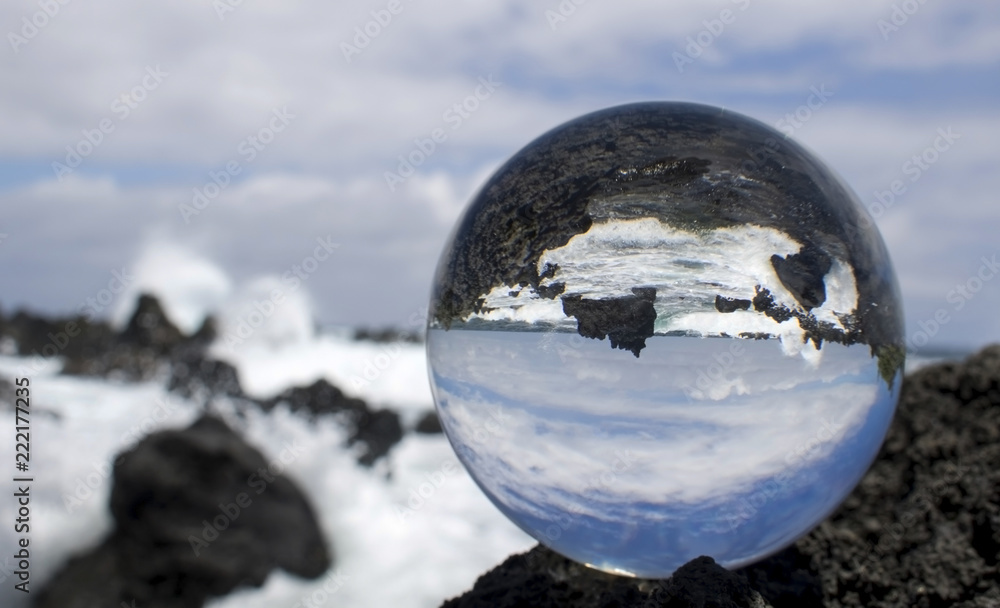 Waves Breaking on Rough Lava Rock in Glass or Crystal Ball Waves Breaking on Rough Lava Rock in Glass or Crystal Ball