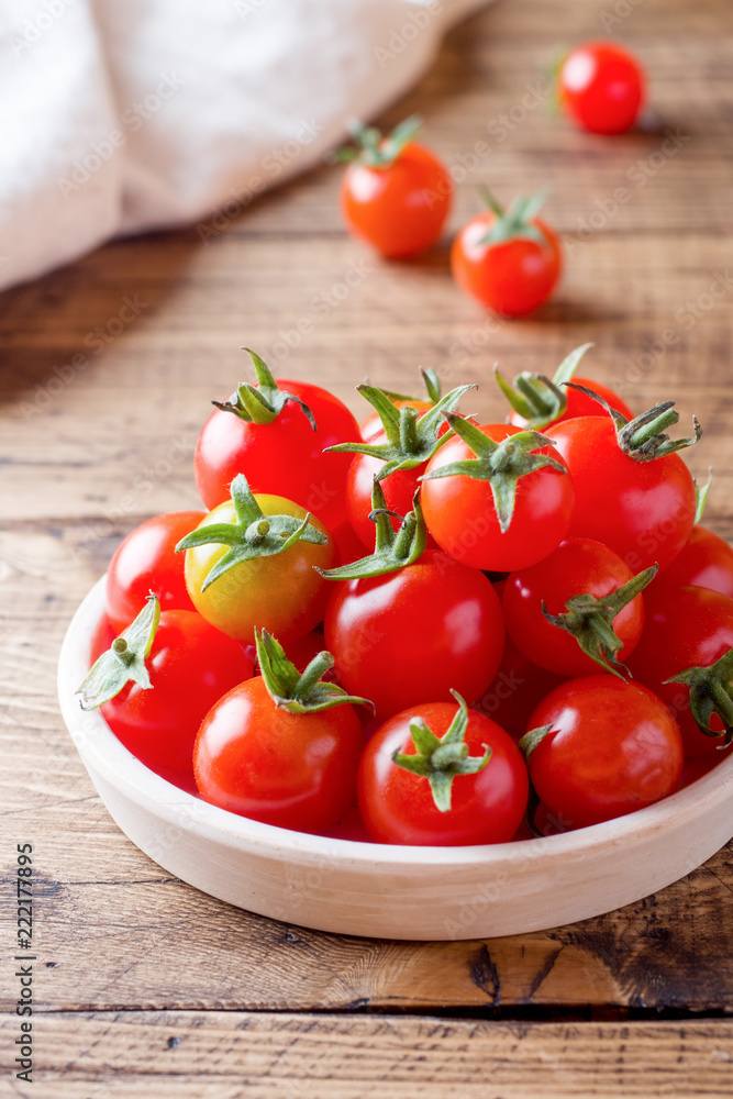 Cherry tomatoes red in ceramic bowl on wooden background Cherry tomatoes red in ceramic bowl on wooden background