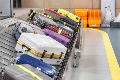 Colorful suitcases on luggage conveyor belt in airport