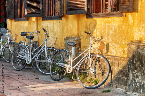 Bicycles parked at yellow wall of old house, Hoi An