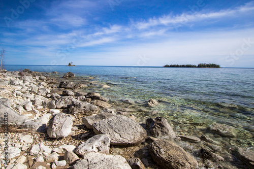 Les Cheneaux Islands In Lake Huron. Sunny day on the rocky coast of Lake Huron with the Les Cheneaux Islands at the horizon. The islanders are a popular destination for kayakers. photo