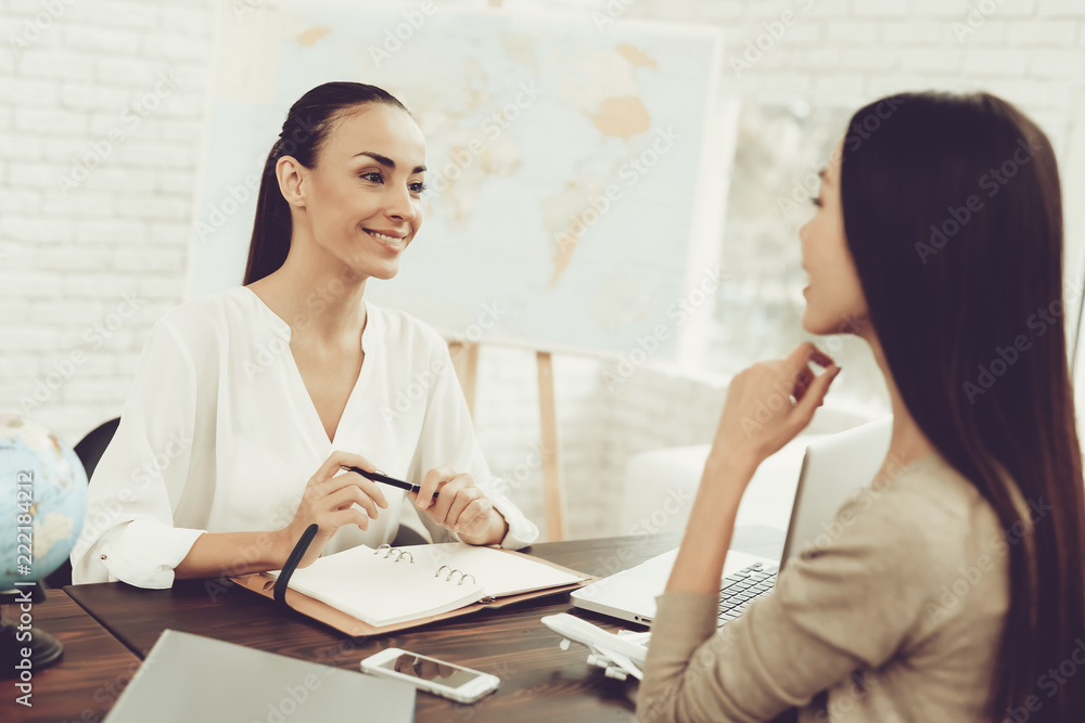 Young Woman in Travel Agency with Smiling Manager. Young Woman in Travel Agency with Smiling Manager.