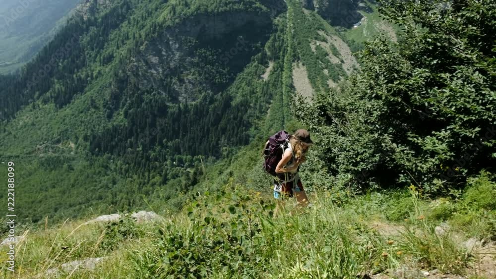 Woman climber hiker tourist rises uphill in the background of beautiful scenery Woman climber hiker tourist rises uphill in the background of beautiful scenery