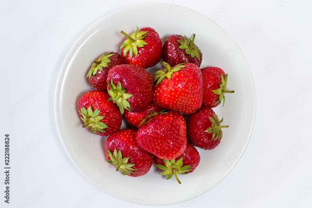 Plate full of tasty juicy strawberries and chocolate isolated on black background Plate full of tasty juicy strawberries and chocolate isolated on black background